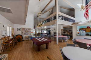 Game room featuring ceiling fan, wood finished floors, high vaulted ceiling, and billiards table