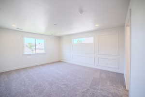 Spare room featuring carpet, a decorative wall, and recessed lighting