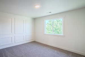 Empty room featuring carpet flooring and baseboards
