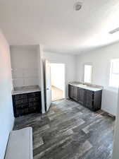 Master bathroom with light countertops, dark wood finished floors, and dark brown cabinetry