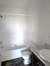 Full bath with shower / bathtub combination, vanity, and dark wood finished floors