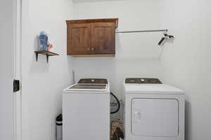 Washroom featuring cabinet space and separate washer and dryer