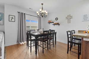 Dining space with light wood-style floors and a chandelier