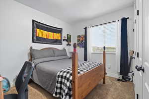 Bedroom featuring carpet and baseboards