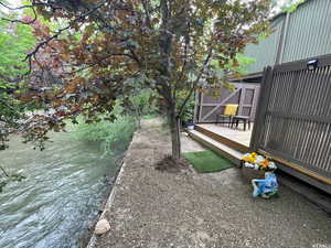 View of yard with a deck with water view