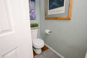 Bathroom featuring a textured wall and wood finished floors