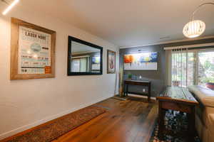 Corridor featuring ornamental molding, dark wood finished floors, and a textured wall