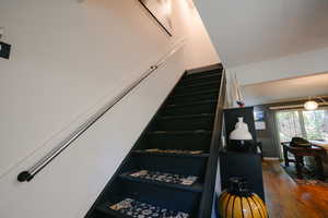 Stairs featuring hardwood / wood-style flooring and crown molding