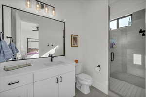 Ensuite bathroom with vanity, a shower stall, and light tile patterned floors