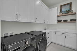 Laundry area with separate washer and dryer and cabinet space