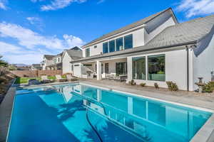 Rear view of house with a patio area, an outdoor hangout area, stucco siding, and a pool with connected hot tub