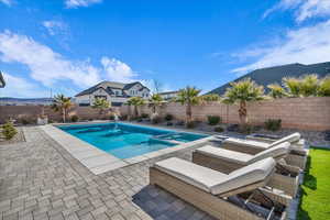 View of pool with a pool with connected hot tub, a fenced backyard, and a patio