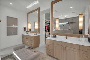Bathroom with two vanities, a walk in shower, recessed lighting, a spacious closet, and light tile patterned floors