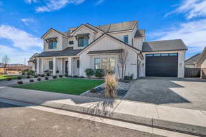 Modern inspired farmhouse featuring a front lawn, a standing seam roof, covered porch, decorative driveway, and a metal roof