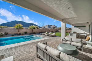 View of swimming pool with an outdoor living space, a patio, a fenced backyard, area for grilling, and a pool with connected hot tub