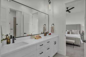 Ensuite bathroom featuring double vanity and a ceiling fan