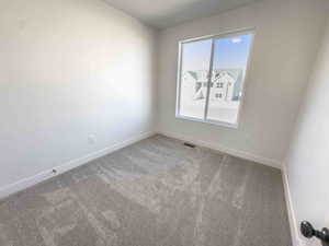 Carpeted spare room with baseboards