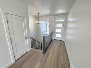 Foyer entrance with a chandelier and light wood-style flooring