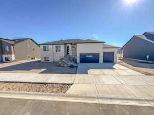 View of front of house featuring a garage, driveway, and stone siding
