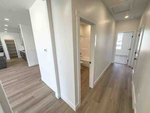 Corridor with recessed lighting and light wood finished floors
