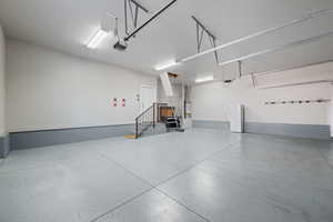 3-car garage with expoxy flooring, 10x10 attic space with lighting, and freezer