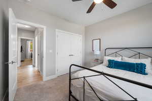 Bedroom featuring light carpet, a closet, and ceiling fan