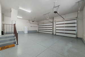 3-car garage with expoxy flooring, 10x10 attic space with lighting, and freezer