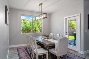 Dining space with light wood-type flooring and a chandelier