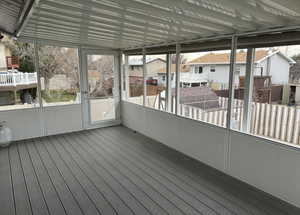 Unfurnished sunroom with a residential view and a wooden deck