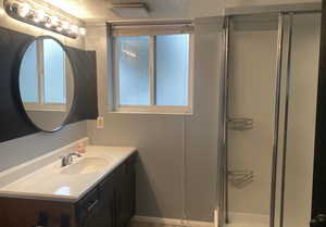 Full bath with plenty of natural light, vanity, a textured ceiling, and a stall shower