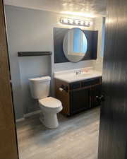 Bathroom with a textured ceiling, vanity, and light wood-type flooring