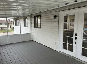 Unfurnished sunroom featuring a wooden deck