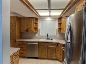 Kitchen featuring open shelves, stainless steel appliances, light countertops, and brown cabinets