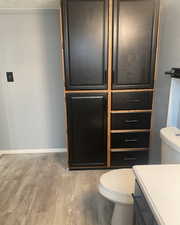 Half bath with light wood-type flooring, vanity, and a textured ceiling