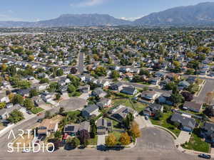 Aerial view of property and surrounding area with mountains and nearby suburban area