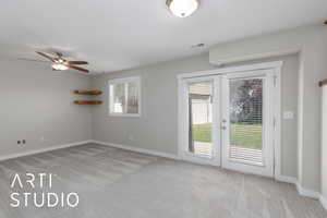 Spare room featuring light carpet, french doors, and ceiling fan