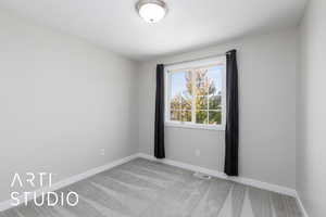 Unfurnished room featuring light colored carpet and baseboards