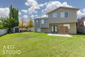 Rear view of house featuring a fenced backyard, a storage unit, french doors, and a patio area