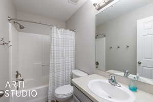 Bathroom with shower / bath combo, vanity, and a textured ceiling