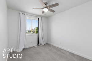 Empty room featuring light carpet and ceiling fan