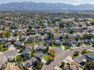 Aerial view of property's location with nearby suburban area and a mountainous background