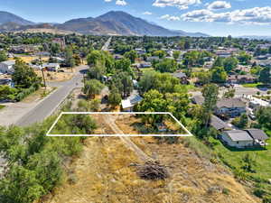 Aerial view of residential area with a mountainous background and property boundaries highlighted