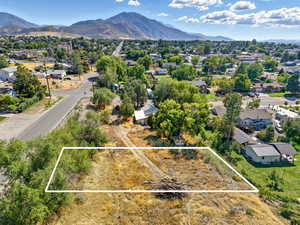 Aerial perspective of suburban area featuring a mountainous background and property boundaries highlighted