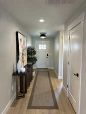Doorway to outside featuring wood-type flooring and recessed lighting