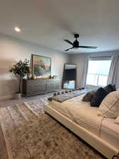 Carpeted bedroom with ceiling fan and baseboards