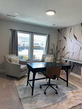 Office area featuring light carpet and a textured ceiling