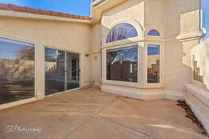 Entrance to property featuring a patio area, stucco siding, and a tiled roof
