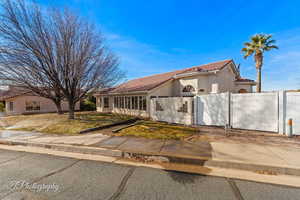 Mediterranean / spanish house featuring a tile roof, stucco siding, and a sunroom