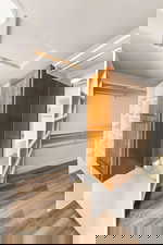 Walk in closet with light wood finished floors and attic access