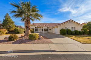 Mediterranean / spanish-style home with driveway, a tile roof, an attached garage, and stucco siding